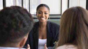 Insurance agent sitting across from and speaking to customers